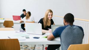Two people on laptops reading a beginner's guide to digital marketing